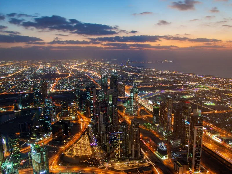 Panorama aereo di Dubai al tramonto con skyline illuminato